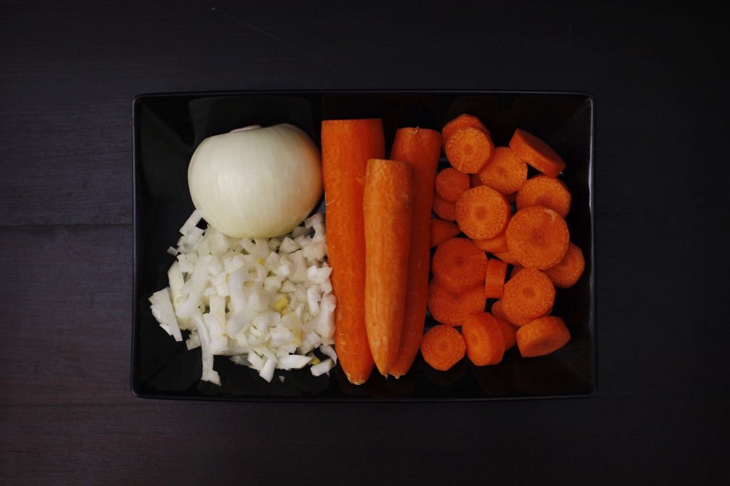 Cortes de la cebolla y la zanahoria para la crema de zanahoria