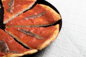 pizza de coliflor con tomate casero y anchoas